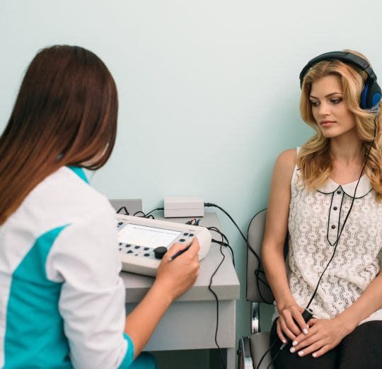 Audiologist conducting hearing test with a patient in a clinical setting